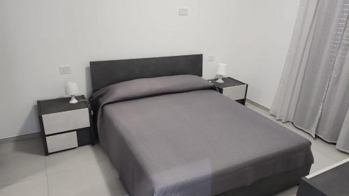 a bedroom with a bed with two night stands and two lamps at Wolfy's Apartment in San Benedetto del Tronto