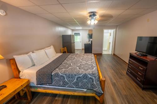 a bedroom with a bed and a flat screen tv at Fishtale Lodge Cabins in Buchanan