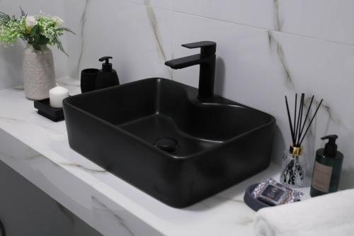 a black sink on a counter in a bathroom at Apartment Simply 205 in Gázion