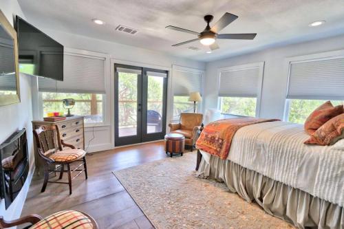 Schlafzimmer mit einem Bett, einem Deckenventilator und Fenstern in der Unterkunft Frontier Ranch Retreat and Cabin in Fischer