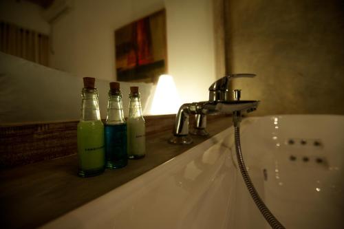 a bathroom sink with three bottles on a counter at Roman Beach Hotel in Hikkaduwa