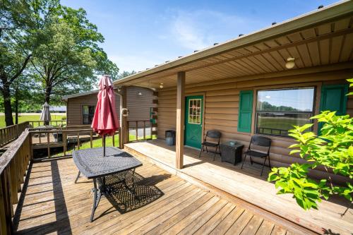 a wooden deck with a table and an umbrella at Fishtale Lodge Cabins in Buchanan