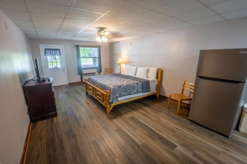 a bedroom with a bed and a refrigerator in it at Fishtale Lodge Cabins in Buchanan