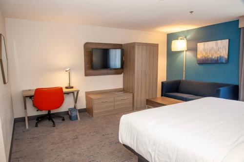 a hotel room with a bed and a desk and a tv at Holiday Inn Express Tucson-Airport by IHG in Tucson
