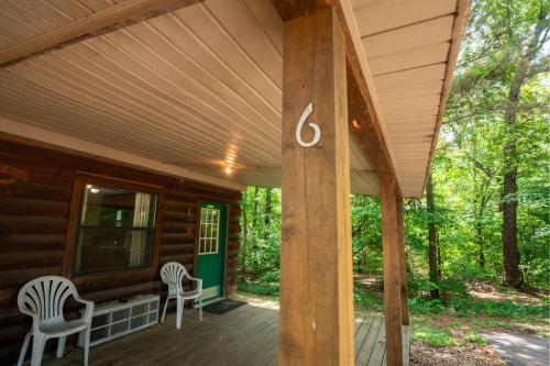 a porch of a cabin with two chairs and a house number at Fishtale Lodge Cabins in Buchanan