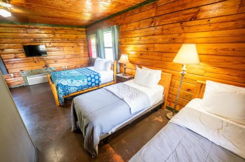 a room with two beds in a log cabin at Fishtale Lodge Cabins in Buchanan