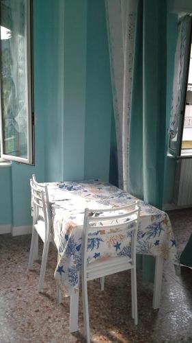 a table and chairs in a room with a blue wall at B&B Elisir in Albenga