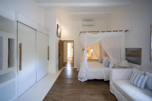 a white bedroom with a bed and a couch at Santa Fe Casas Hotel Trancoso in Trancoso
