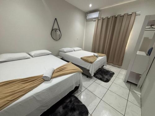 a room with two beds and a mirror at Rodrigues AP Apartamento em Barreirinhas in Barreirinhas