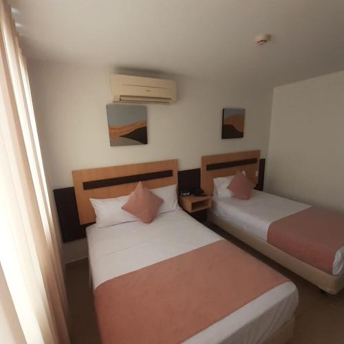 two beds in a small room with at Corona Real Hotel in Guayaquil