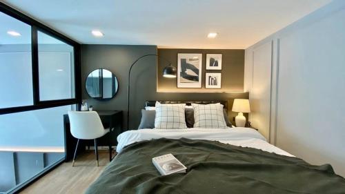 een slaapkamer met een bed, een bureau en een raam bij Modiz Modiza Sukhumvit R4 in Bangkok