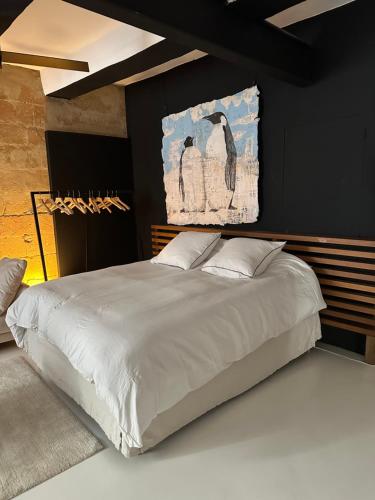 une chambre avec un grand lit avec un tableau au mur dans l'établissement La Suite 4 Dauphins- Aix en Provence, à Aix-en-Provence