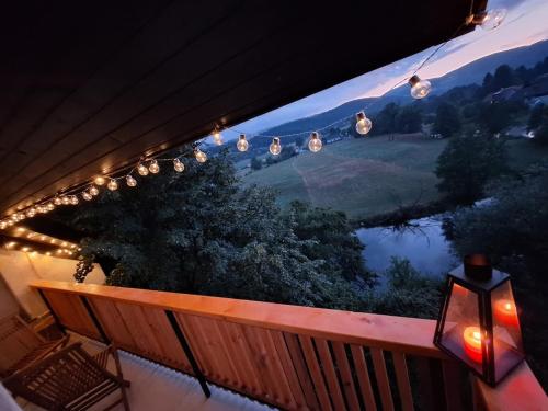 a balcony with a view of a lake and lights at Hiška na skalci, The House on the Rock in Krka