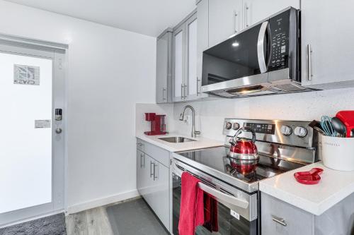 a kitchen with white cabinets and a stove top oven at 8 Mi to Design District Miami Home with Yard in Miami