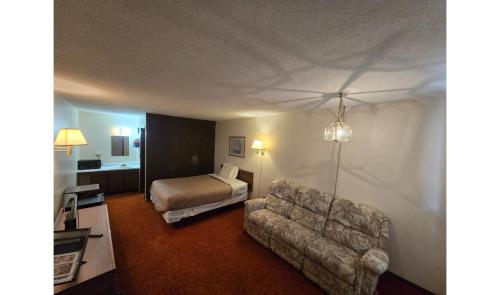 a hotel room with a bed and a couch at OYO Sandman Inn in Eagle Grove
