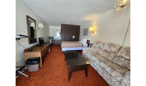 a living room with a couch and a bed at OYO Sandman Inn in Eagle Grove