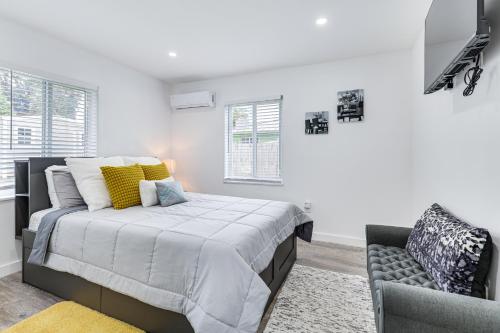 a white bedroom with a bed and a chair at 8 Mi to Design District Miami Home with Yard in Miami