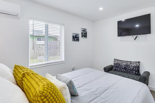 a white bedroom with a bed and a tv at 8 Mi to Design District Miami Home with Yard in Miami