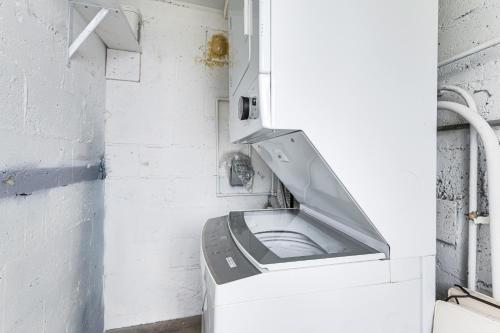 a toilet in a room with a white wall at 8 Mi to Design District Miami Home with Yard in Miami
