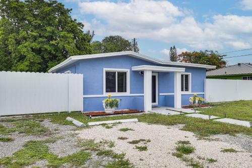 a blue house with a white fence in a yard at 8 Mi to Design District Miami Home with Yard in Miami
