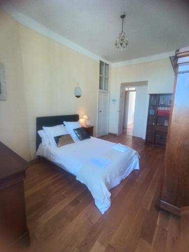 une chambre avec un grand lit blanc et un parquet dans l'établissement côté palais, à Bastia