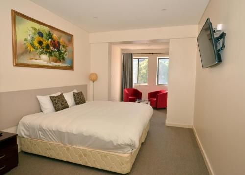 ein Hotelzimmer mit einem Bett und einem TV in der Unterkunft Parklane Motel Murray Bridge in Murray Bridge