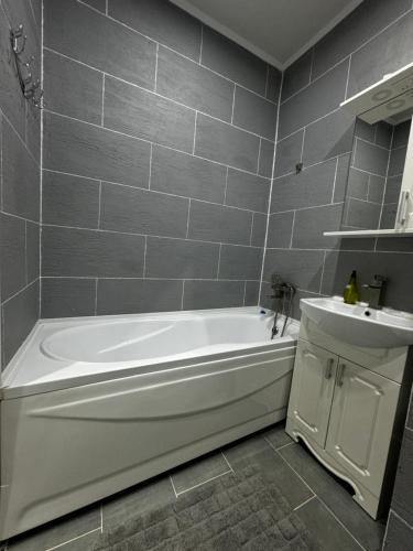 a bathroom with a white tub and a sink at Rent&live calm place apartment in Crăsnăşeni