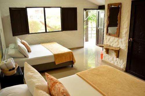 a bedroom with two beds and a mirror in it at Finca Hotel Loma Verde in Quimbaya