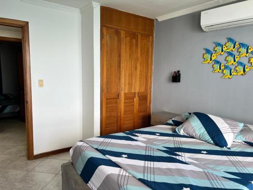 a bedroom with a bed and a wooden door at Alojamiento Peñón del rodadero in Santa Marta