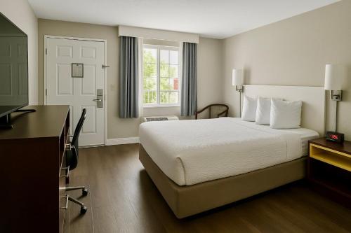 a hotel room with a bed and a desk at Days Inn by Wyndham Bradenton I-75 in Bradenton