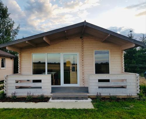 a small house with a porch and glass doors at BohoWicko in Jezierzany