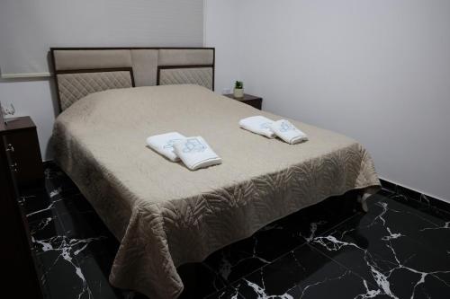 a bed with two towels on top of it at Sky High Guesthouse in Gharīfah