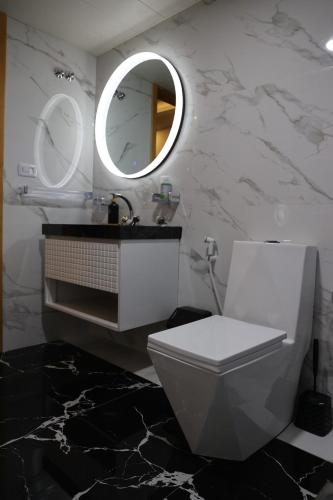 a bathroom with a white toilet and a mirror at Sky High Guesthouse in Gharīfah