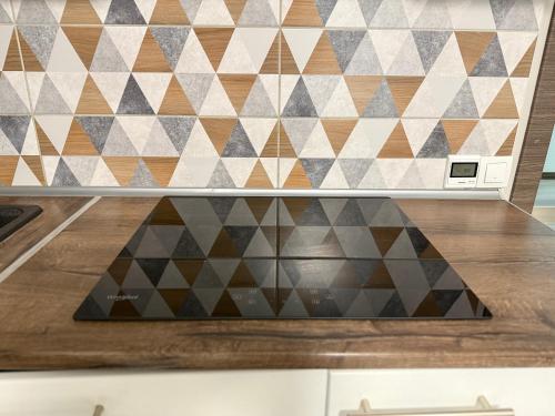 Una encimera de cocina con una pared con un patrón geométrico. en ПОМЕШКАННЯ на площі Польський ринок, en Kamianets-Podilskyi