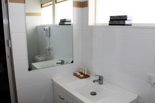 a bathroom with a sink and a mirror at Hospitality Geraldton, SureStay by Best Western in Geraldton