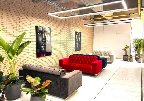 a waiting room with red couches and a brick wall at Parque 93 apartamento ideal in Bogotá