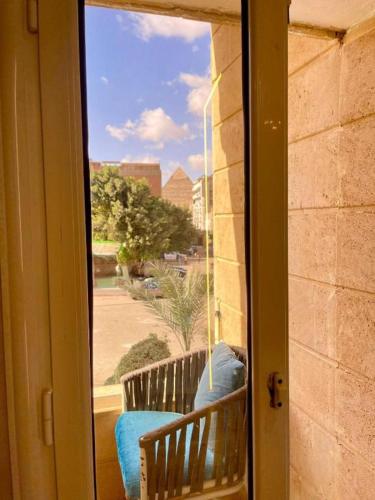 a view of a porch with a bench through a window at Cleo Patra Pyramids Tower Inn in Banī Ghālib