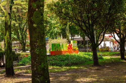 a sign in the middle of a park with trees at Parque 93 apartamento ideal in Bogotá