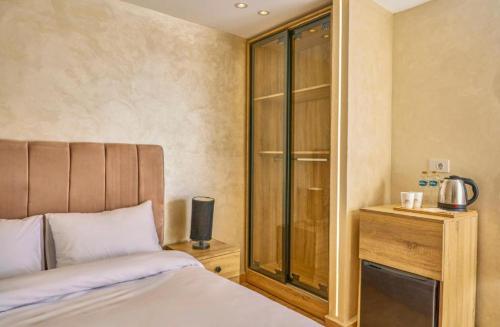 a bedroom with a bed and a glass closet at Cleo Patra Pyramids Tower Inn in Banī Ghālib