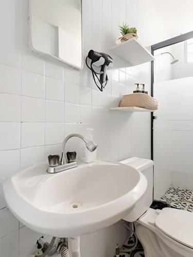 a white bathroom with a sink and a toilet at Acogedor departamento, centro histórico Monterrey in Monterrey