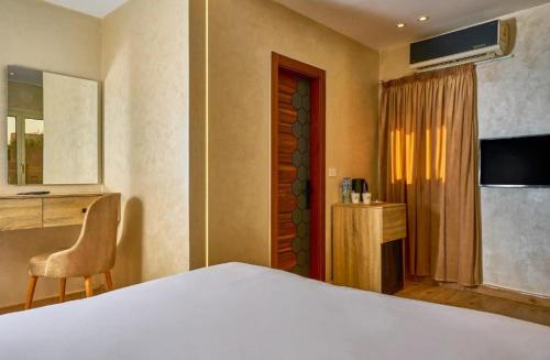 a bedroom with a bed and a chair and a desk at Cleo Patra Pyramids Tower Inn in Banī Ghālib