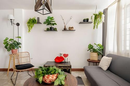 a living room with plants on the walls and a couch at Acogedor departamento, centro histórico Monterrey in Monterrey