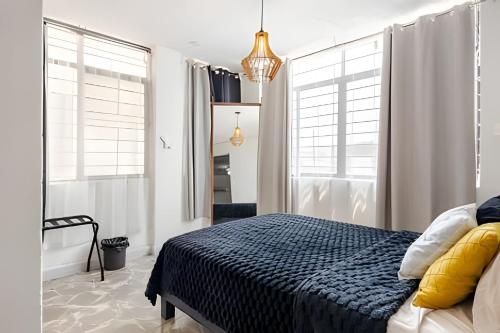 a bedroom with a bed and two large windows at Acogedor departamento, centro histórico Monterrey in Monterrey