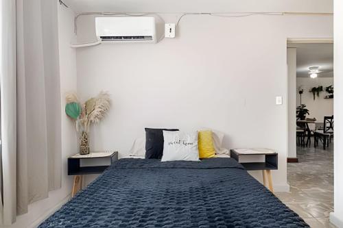 a bedroom with a bed with a blue comforter at Acogedor departamento, centro histórico Monterrey in Monterrey