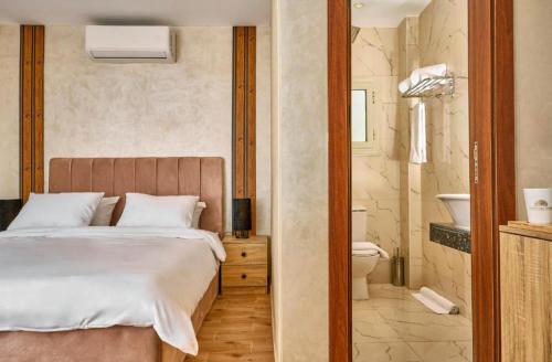 a bedroom with a bed and a bathroom with a toilet at Cleo Patra Pyramids Tower Inn in Banī Ghālib