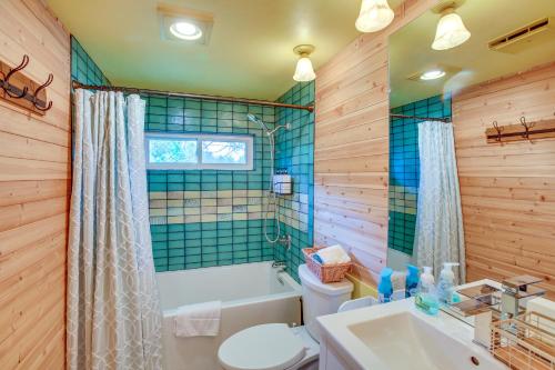 a bathroom with a tub and a toilet and a sink at 8 Mi to Crystal Mountain Peaceful Up North Home in Thompsonville