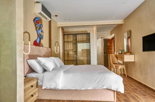 a bedroom with a large white bed and a kitchen at Cleo Patra Pyramids Tower Inn in Banī Ghālib