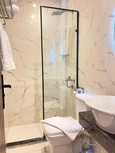 a bathroom with a shower and a toilet and a sink at Cleo Patra Pyramids Tower Inn in Banī Ghālib