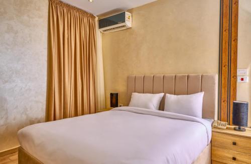 a bedroom with a large white bed and a window at Cleo Patra Pyramids Tower Inn in Banī Ghālib