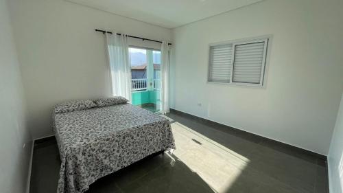 a bedroom with a bed and a window at Cantinho aconchego gc in Ubatuba